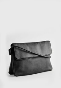 Bolso de mano de cuero negro con solapa plegable, superficie texturizada y una delgada correa para el hombro. Diseño compacto adecuado para lo esencial.