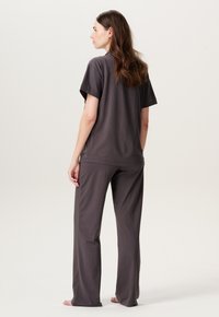 Dunkelgraues Baumwoll-Loungewear-Set mit einem kurzärmeligen Oberteil und locker sitzenden Hosen. Glatte Textur mit entspannter Passform.