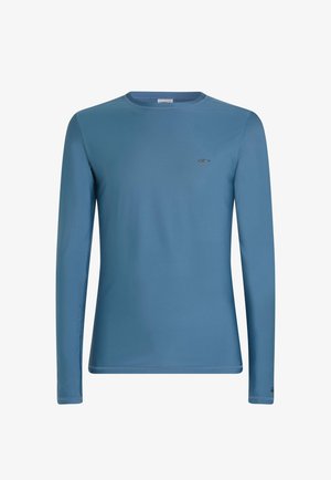 Dlouhý rukáv košile z jasně modré látky, s kulatým výstřihem a malým logem na hrudi. Hladká textura s přiléhavým střihem.