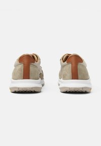 Bežsuede tenisice s smeškim kožnim detaljem na peti, bijelim međupodlogom, teksturiranim gumenim potplatom i zaobljenim dizajnom.