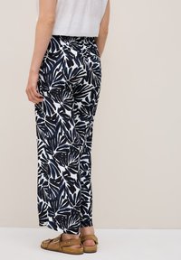 Patterned wide-leg trousers featuring a navy leaf design on a white background, made from lightweight fabric, with an elastic waistband.