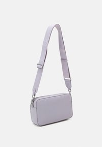 Borsa rettangolare lilla con superficie liscia, tracolla regolabile e accessori in argento. Presenta una chiusura con zip e una tracolla con logo in rilievo.