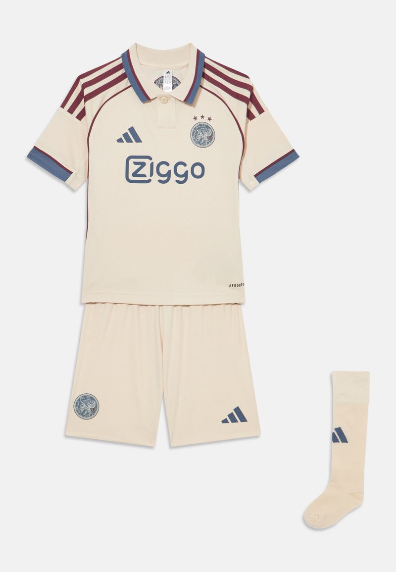 Cream soccer kit includes a polo shirt with maroon and blue accents, shorts, and matching socks. Features logo and three stars on shirt.