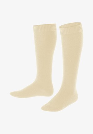 Beżowe skarpetki do kolan o miękkiej, żebrowanej strukturze z dopasowanym mankietem na górze i gładkim wykończeniu przez całość. Odpowiednie na różne okazje.