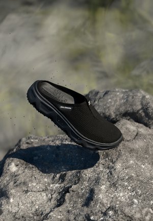 Czarne siateczkowe buty typu slip-on z fakturowaną cholewką, wyprofilowaną podeszwą i trwałą gumową podeszwą. Logo marki widoczne z boku.