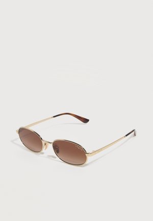 Ovalne sončna očala z zlatimi kovinskimi okvirji in rjavimi obarvanimi lečami, z tankimi kraki in temno rjavimi konicami na straneh.