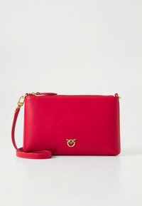 Červená kožená kabelka do ruky s hladkou strukturou, zdobená zlatým logem, odnímatelným ramenním popruhem a zapínáním na zip.