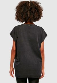 Overdimensioneret sort bomuld T-shirt med rund halsudskæring, kortærmer og synlige sømdetaljer. Blødt, afslappet design med en løs pasform.