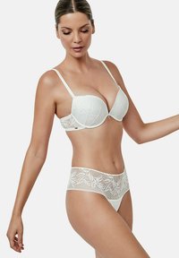 Witte kanten beha en bijpassende slip. De beha heeft gepadded cups en verstelbare banden. De slip heeft een bloemenkantpatroon langs de tailleband.