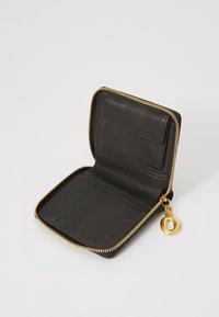 Portefeuille en cuir noir avec une fermeture zippée, plusieurs emplacements pour cartes, texture lisse et un charme en métal doré sur la tirette du zip.