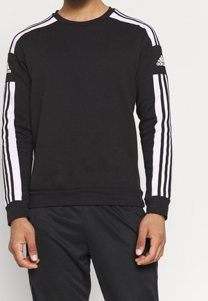 Czarny sweter z długim rękawem, z białymi paskami po bokach i logo Adidas na lewym rękawie. Miękka tekstura, casualowy fason.