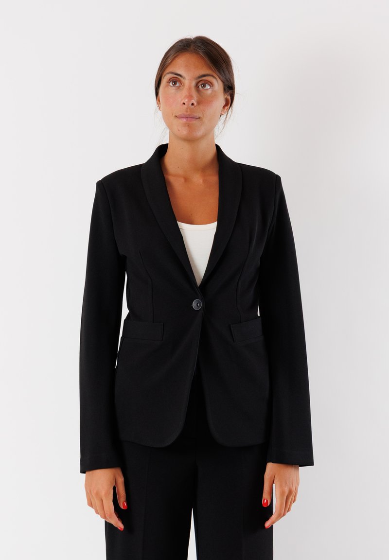 Blazer nero con chiusura a un bottone, colletto affilato, due tasche frontali e vestibilità su misura. Realizzato in un tessuto morbido.