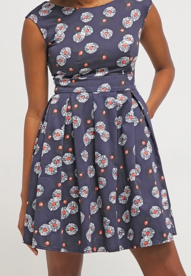 Námořnické šaty s květinovými vzory, krátkými rukávy, přiléhavým korzetem a skladanou sukní. Vyrobeno z lehkého materiálu s hladkou strukturou.