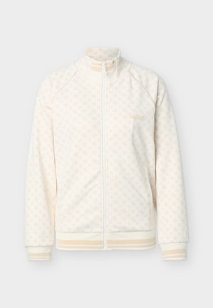 Witte jack met ritssluiting, met een lichtbeige geometrisch patroon, hoge kraag, zijzakken en geribbelde manchetten en zoom met beige strepen.