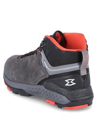Botte de randonnée grise avec un dessus en daim et synthétique, intérieur orange, accents noirs, côté texturé et semelle extérieure en caoutchouc rouge. Comprend un système de laçage et un logo.