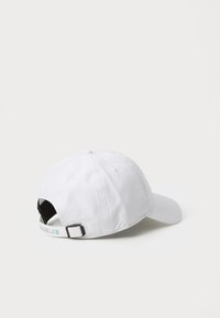 White cotton baseball cap with a rounded shape, adjustable strap at the back, and a multicolored "LOS ANGELES" text accent on the strap.