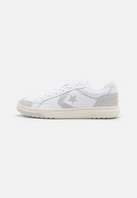White leather sneakers with gray suede accents, star logo on side, textured toe cap, and cream rubber sole. Classic lace-up design.