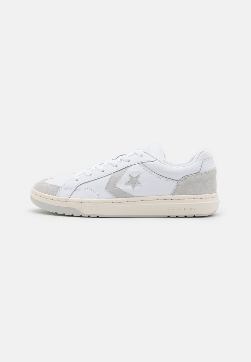 White leather sneakers with gray suede accents, star logo on side, textured toe cap, and cream rubber sole. Classic lace-up design.