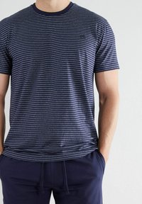 Marineblau gestreiftes T-Shirt aus weicher Baumwolle mit kurzen Ärmeln und Rundhalsausschnitt. Verfügt über dezente vertikale und horizontale Streifen.