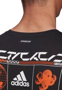 Schwarzes sportliches T-Shirt mit rundem Hals, Logodruck und abstrakten orangefarbenen Grafiken auf der Rückseite, gefertigt aus atmungsaktiven Materialien.