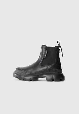 Black leather ankle boots with elastic side panels, chunky rubber sole, and a pull tab at the back. Smooth texture with logo detailing.
