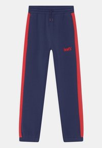 Marineblaue Jogginghose mit roten Seitenstreifen. Elastischer Bund mit Kordelzug. Verfügt über Taschen und ein gesticktes Logo auf dem linken Oberschenkel.