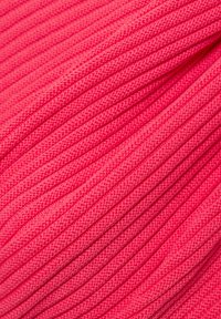 Fuchsia-farbener Stoff mit einer strukturierten, gerippten Optik und sichtbaren Nähdetails, die ein dynamisches, mehrlagiges Erscheinungsbild erzeugen.