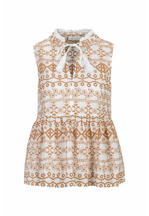 Blouse blanche sans manches avec col à volants, broderie florale et géométrique marron, et détail de lien à pompons à l'avant.