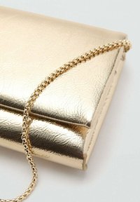 Guldfarvet metal clutch taske med en tekstureret overflade. Har en kædestoftype og en slank, rektangulær form med en klaplukning.