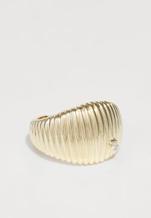 Gold-toned ring featuring a ribbed design with a smooth texture. Accented by a small embedded clear stone near the band.