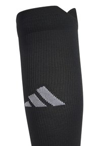 Mustat urheilusukat, joissa on uritettu pinta ja kapeneva yläosa. Sukissa on valkoinen Adidas-logo nilkan lähellä. Valmistettu joustavasta materiaalista.