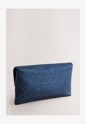 Granatowa kopertówka z fakturowaną powierzchnią ozdobioną różnej wielkości błyszczącymi niebieskimi i srebrnymi kryształkami. Prostokątny kształt, zamknięcie magnetyczne.