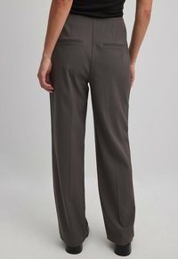 Wijdvallende broek in donkergrijze stof, met twee achterzakken en een gladde textuur, met een hoge taille en een nauwsluitende pasvorm.