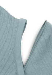 Tissu tricoté bleu clair avec un motif texturé, doté d'un col et d'un détail à fermeture éclair sur un bord. Le matériau semble doux et extensible.