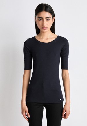 Navyblauw aansluitend t-shirt met korte mouwen, ronde halslijn en een gladde textuur. Heeft een klein logo detail nabij de zoom.