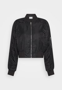 Svart kort bomberjacka i slät, glänsande tyg; har en dragkedja framtill, ribbade muddar och sidoficka med dragkedja.