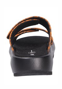 Sandali con platform neri e cinturini in suede marroni e arancioni. Il plantare è in materiale nero texturizzato; la suola presenta una leggera curvatura per supporto.
