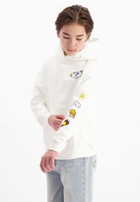 Witte hoodie met een kangoeroezak, versierd met kleurrijke geborduurde ontwerpen van een zon, wolk, kameel en geometrische patronen op de mouwen.