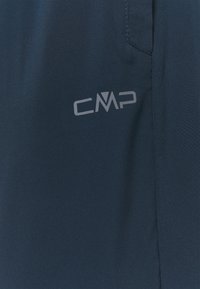Tecido azul marinho com uma textura suave, apresentando um logo cinza da CMP de um lado e um detalhe de bolso lateral.