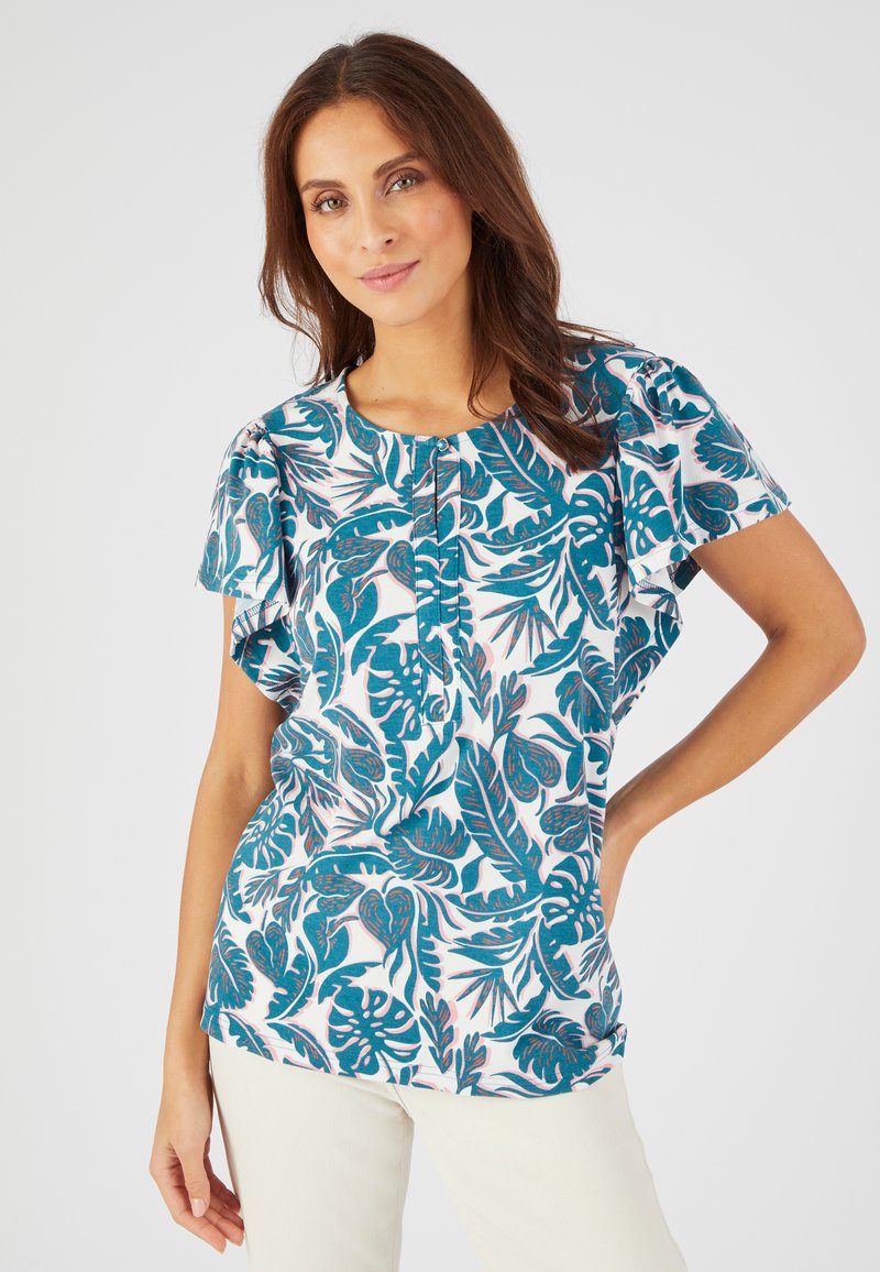 Blusa de manga corta con un patrón de follaje en tonos verde azulado y rosa sobre un fondo blanco. Cuello redondo con detalle de botones y corte holgado.