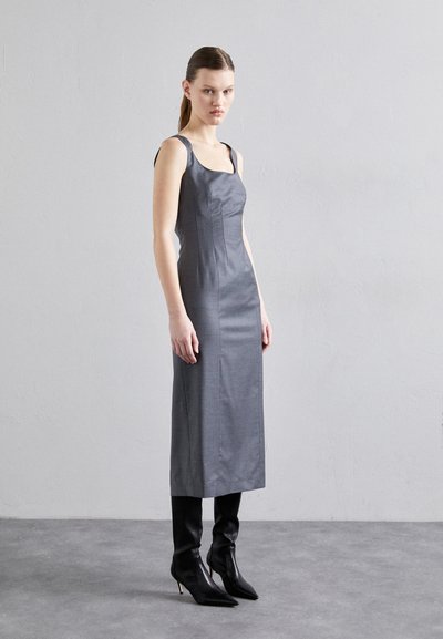 Rochie gri ajustată cu decolteu pătrat, bretele și textură netedă, asortată cu bocanci negri cu vârful ascuțit, creând o siluetă elegantă.