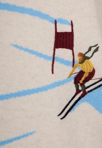 Tessuto a maglia con sciatori ricamati in giallo e rosso, che scivolano su piste di neve blu, con un cancello bordeaux sullo sfondo.