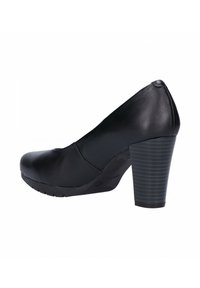 Zapato de tacón alto negro hecho de cuero suave con punta redondeada, que presenta un tacón cuadrado texturizado y sin logotipos ni adornos visibles.