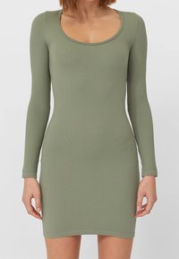 Robe à manches longues côtelée de couleur vert olive. Comprend un col arrondi et une silhouette ajustée. Texture douce avec une finition lisse.