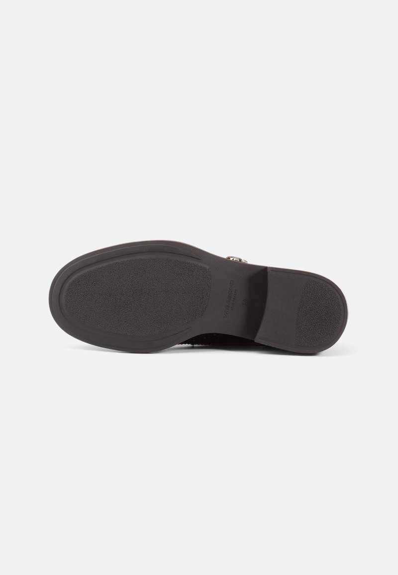 Suola di scarpa in gomma nera con superficie texturizzata, forma sagomata e tacco leggermente rialzato. Nome del marchio stampato vicino al tallone.