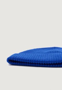 Beanie tricotat albastru, cu textură ribbed, margine pliată și vârf rotunjit. Țesătura pare moale și groasă, potrivită pentru căldură.