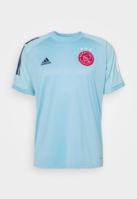 Camisa deportiva de color azul claro con mangas cortas, que presenta rayas azul oscuro, un logo rojo bordado y tres estrellas blancas encima.