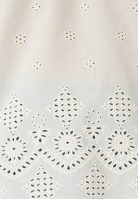 Tessuto di cotone ricamato in azzurro chiaro con motivi floreali bianchi intricati e dettagli a giorno lungo il bordo inferiore.