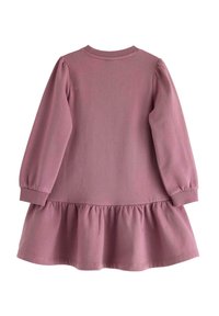 Långärmad, rosa bomullsklänning med rund halsringning och puffärmar. En samlad volang vid fållen ger designen en detalj.