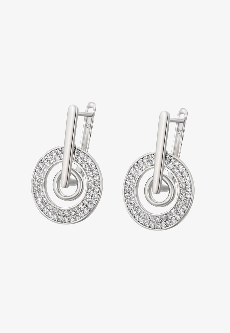 Stříbrné kruhové náušnice s vertikálním prutem a kulatým okem osázeným malými třpytivými průhlednými kamínky, zobrazené na bílém pozadí.